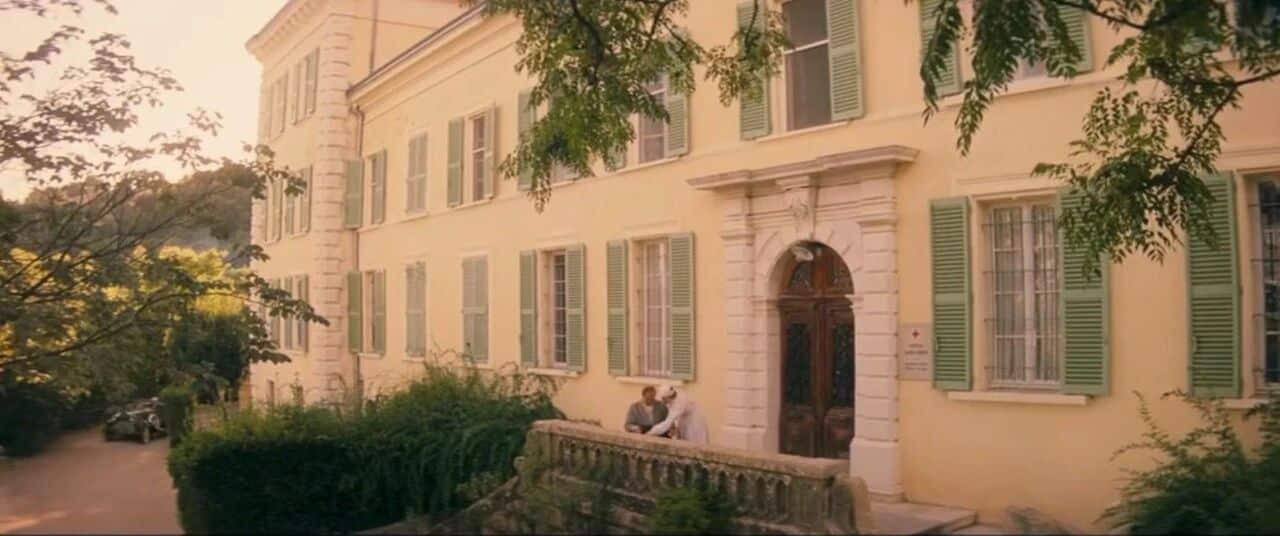 魔力月光-一座优雅的黄色建筑前,两位人物坐在石阶上交谈