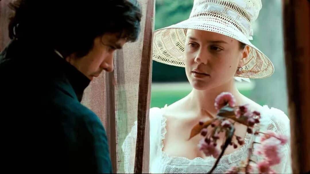 明亮的星-女主角戴着白色帽子，手持花朵，与男主角在窗边深情对视