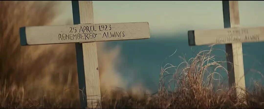 大洋之间的灯光-海边的纪念十字架，上面刻有日期和“永远铭记”的字样