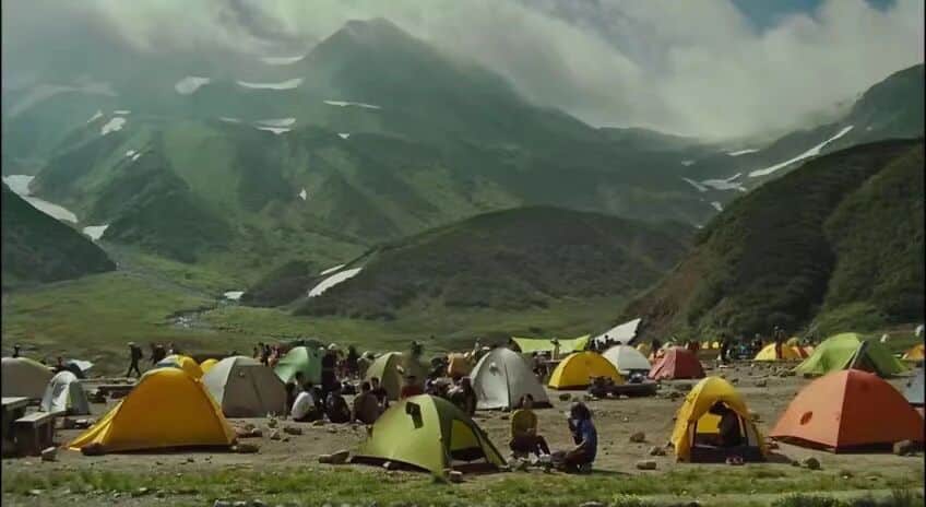 背负春天-户外营地中五颜六色的帐篷，背景是雄伟的山脉