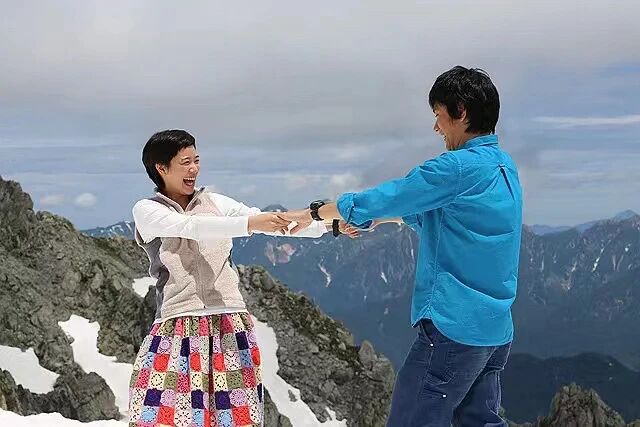 背负春天-男女主角在山顶上手拉手大笑
