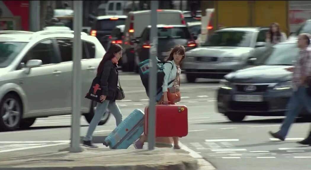 普通人行为指南两位女主角拖着行李箱在繁忙的街道上行走