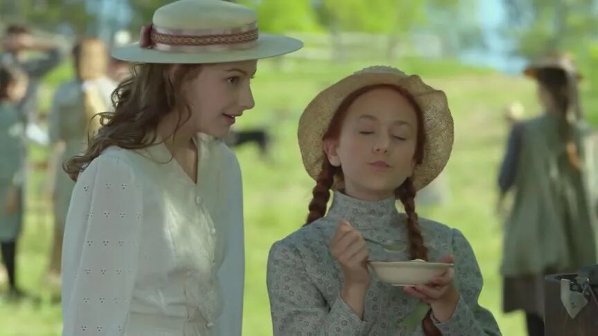 清秀佳人女主角安妮·雪莉在户外手持碗，与另一位女孩交谈