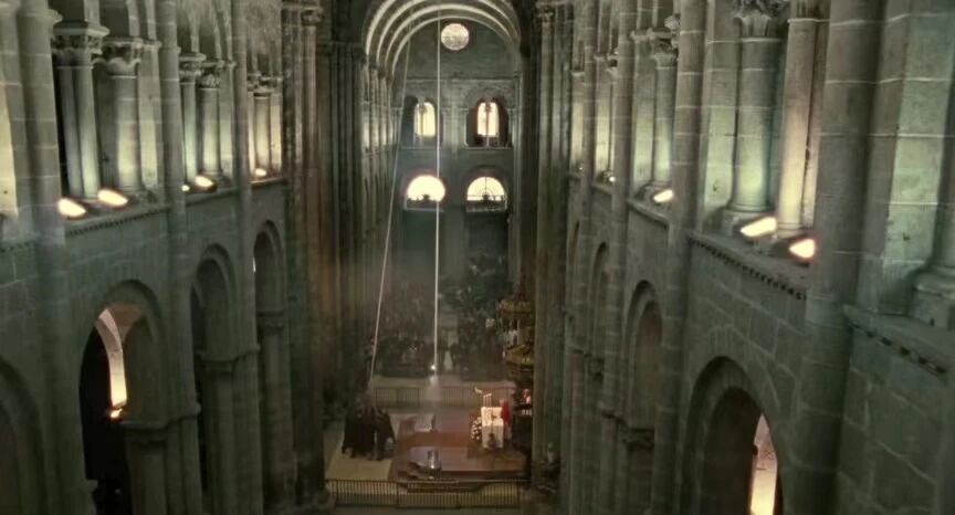 朝圣之路教堂内部的高角度视角，展示了宏伟的拱顶梁和彩色玻璃窗