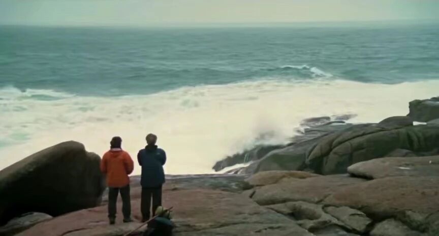 在朝圣之路的尽头，两人矗立于嶙峋的礁石之上，直面着咆哮而来的巨浪